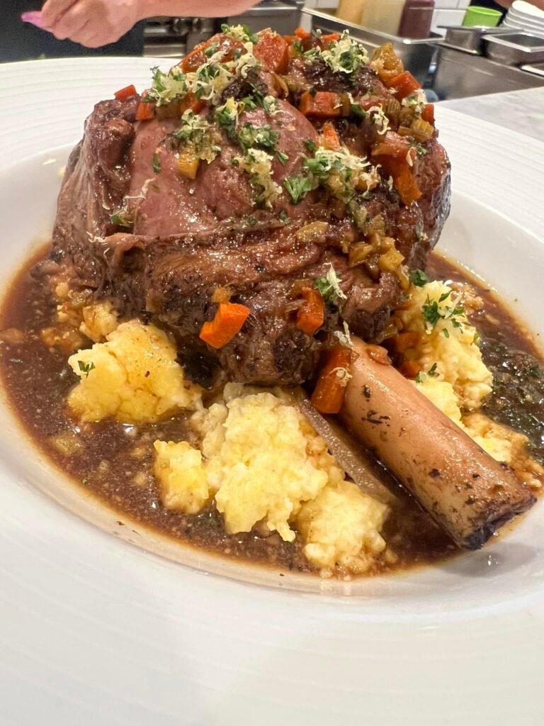 Lamb Shank over cheddar grits, Wente “Charles Wetmore” Cabernet Demi glacé, gremolata.